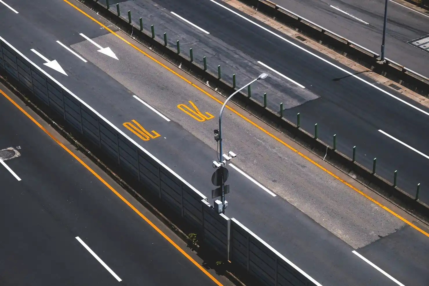 A high-view motorway with white, yellow, and broken lines.