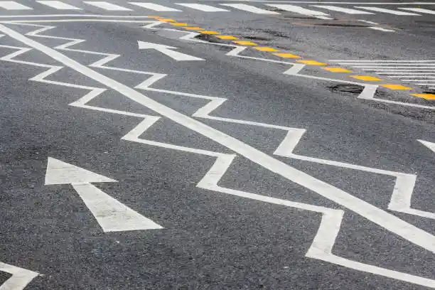 A road marked with a solid white line and zigzag lane markings.