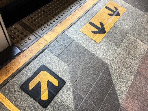 Directional floor arrows and tactile walkway markings guiding pedestrian movement.