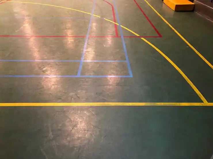 Indoor gymnasium floor with precise multi-sport court markings.