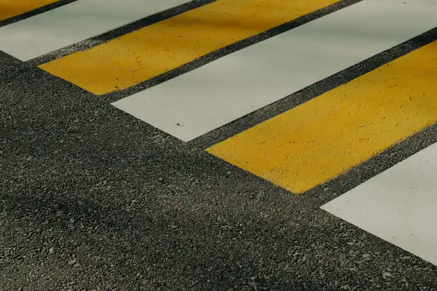 Roadway and pedestrian line markings on an asphalt surface in Ajax.