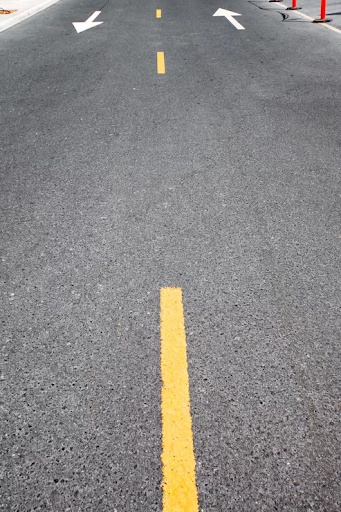 White directional arrows painted on asphalt.