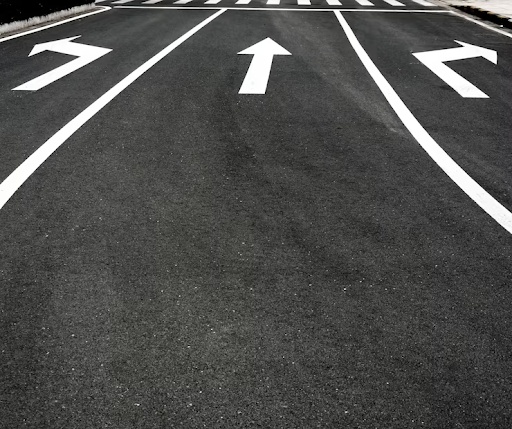White road arrows on black asphalt.