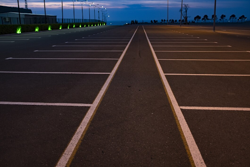 Empty parking lot with white lines at dusk